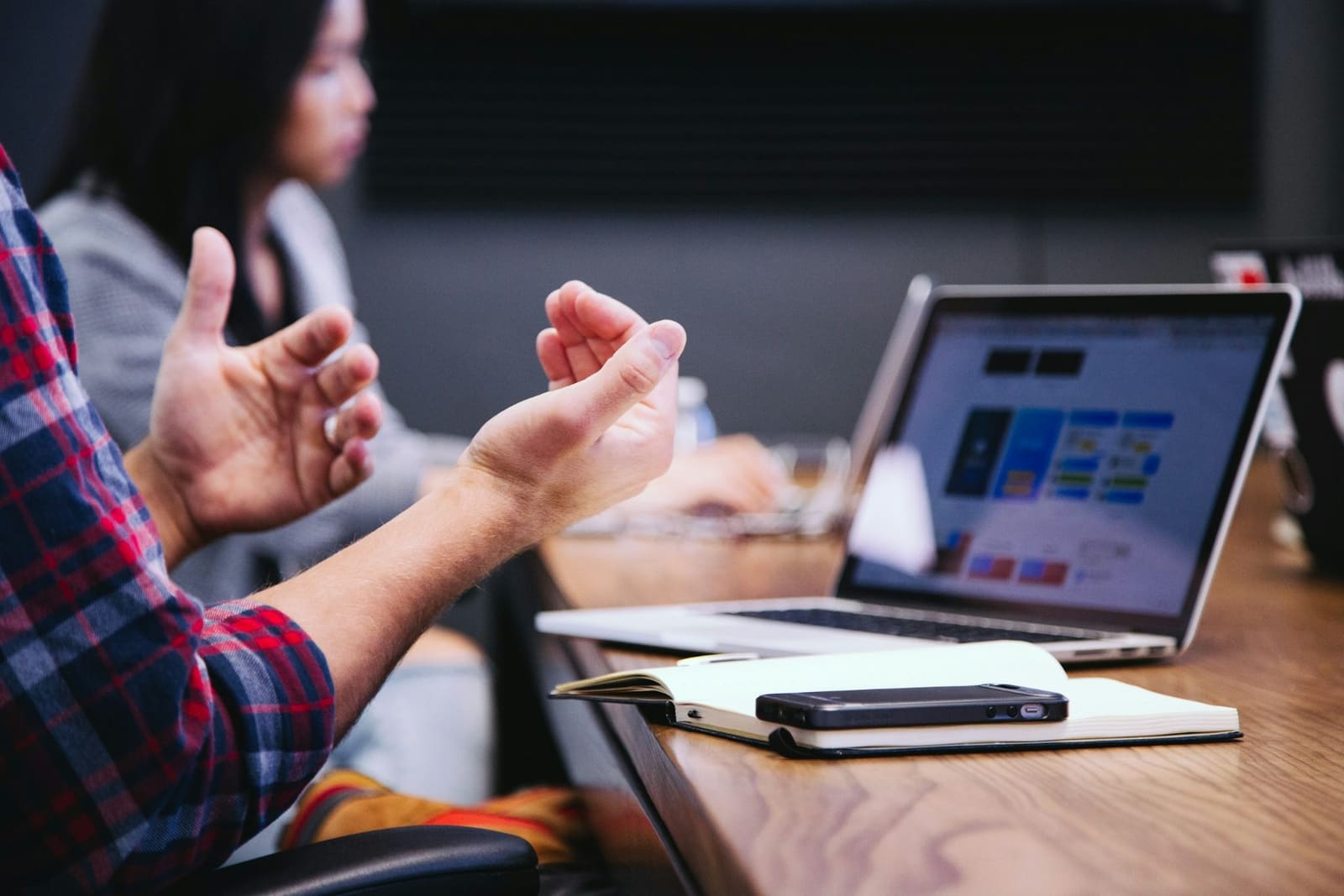 Hands gesturing mid-conversation at a meeting table